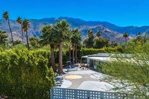 A modern outdoor area with palm trees, a seating area, and a building with solar panels. - Welcome to a Vibrant Retreat Located in Palm Springs' Historic El Mirador Neighborhood (Palm Springs)