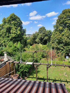 A rooftop with a view of a lush garden and distant houses. - Holiday Home 'Joanna' with Mountain View, Private Terrace and Wi-Fi (Hennef)