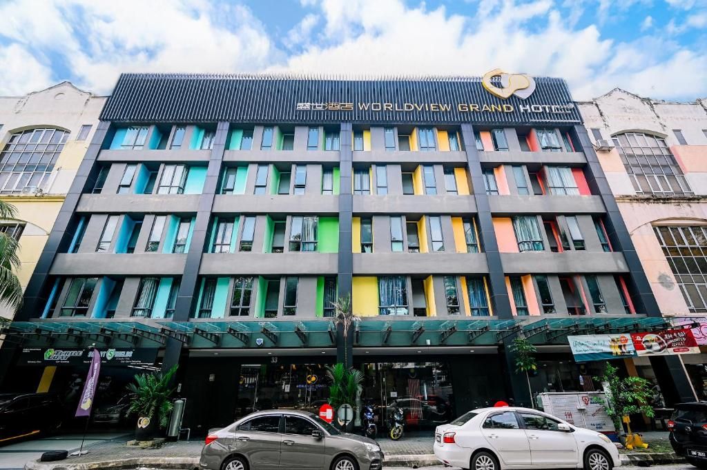 A multi-story hotel with a modern facade, featuring a prominent sign for the 'WORLDVIEW GRAND HOTEL.'