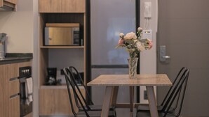 Una cocina moderna con armarios de madera, un refrigerador integrado y una mesa de comedor con sillas.