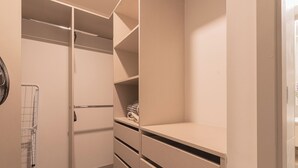 Un closet amplio con repisas abiertas, una percha y una toalla doblada en la repisa inferior.
