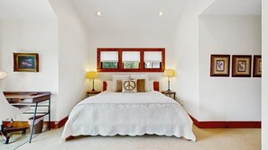 A bedroom with a large bed, a desk, and a window with blinds. - Luxury Lakefront Condo, Gated Community, Mountain & Lake Views, Pool, Dock, & Kayaks (Lake Lure)