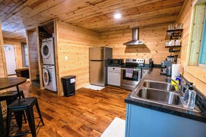 Eine kompakte Küche mit Waschmaschine, Kühlschrank, Mikrowelle, Backofen und Spüle.