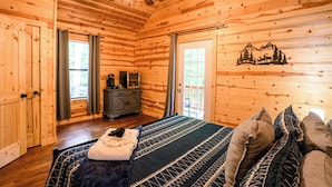 A wooden cabin interior with a bed, a dresser, and a ceiling fan. - Buttercup - Cozy Retreat - Central - WiFi (Gillmore)