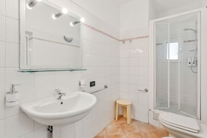 A bathroom with a white sink, mirror, and glass shower enclosure. - [StairwayToHeaven Room 1] 5Terre-Seaview (Riomaggiore)