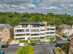 Ein mehrstöckiges Wohngebäude mit moderner Architektur, mit Balkonen und großen Fenstern.