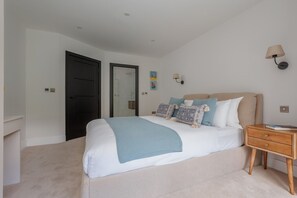 Un dormitorio con cama, mesita de noche y una puerta.