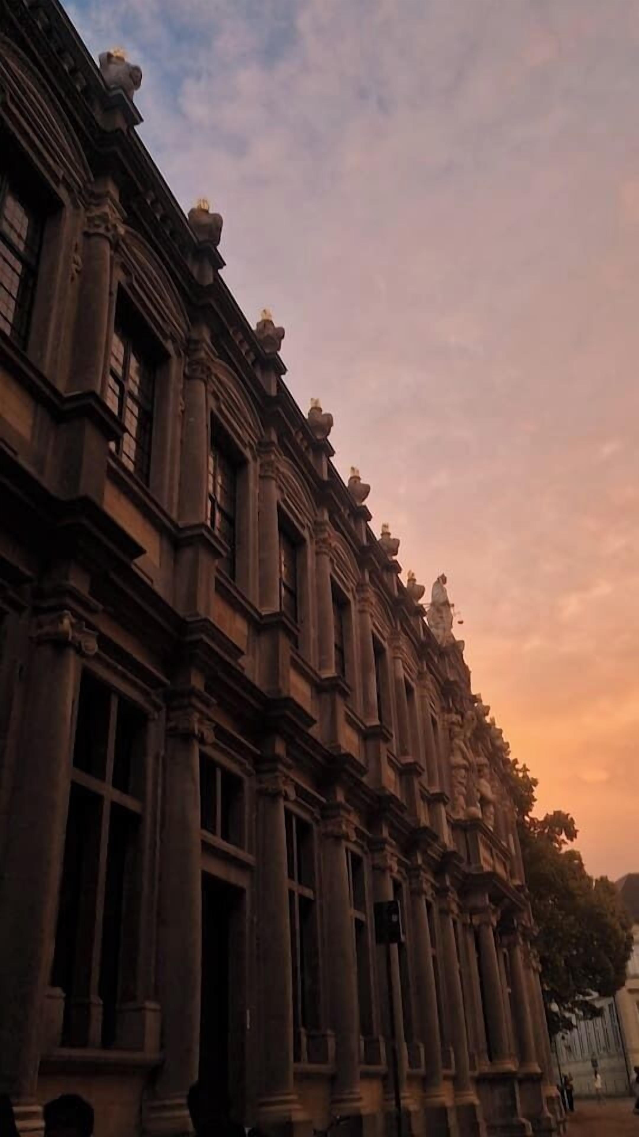 Un bâtiment de style classique, doté de colonnes richement décorées et d’une architecture soignée.