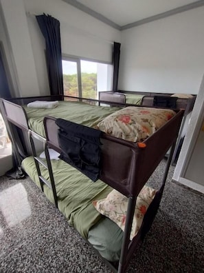 A room with bunk beds, a window with curtains, and a carpeted floor. - Flamingo by Nest (Santa Eulalia del Rio)