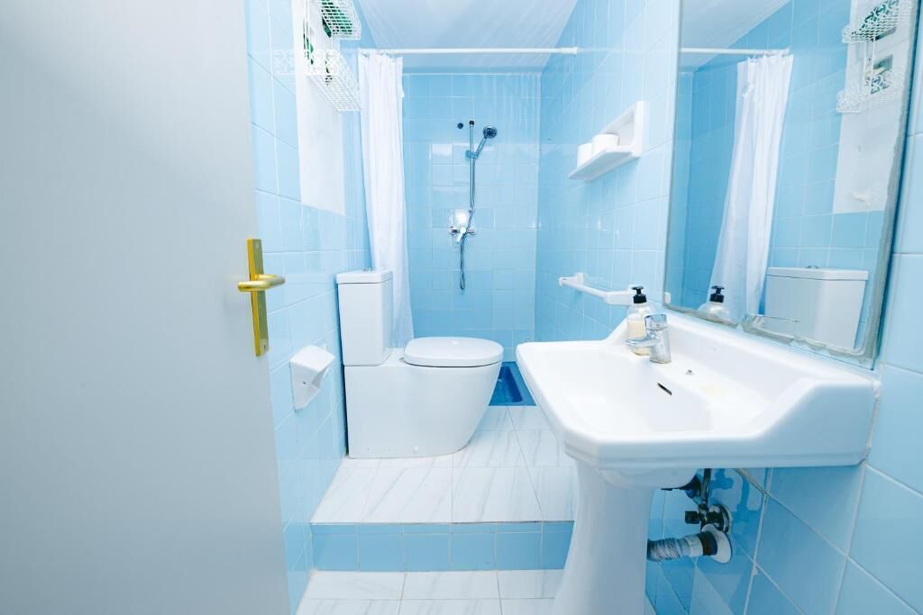 Un baño con inodoro, lavamanos y ducha.