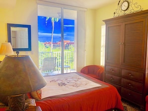 A room with a bed, a chair, a lamp, a wardrobe, and a balcony with a view. - Spacious 3-bedroom condo in lovely Naples with fitness room (Naples)