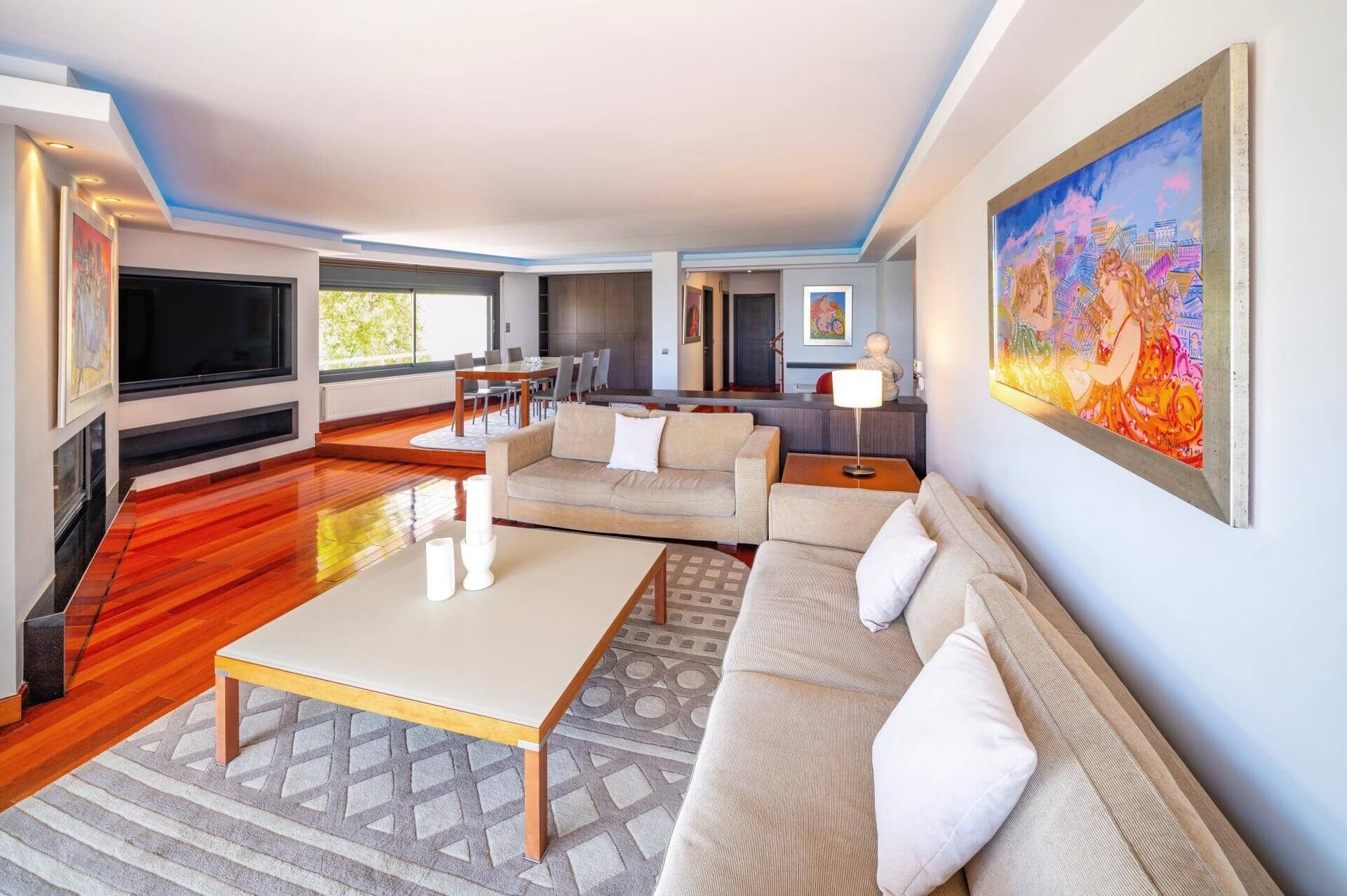 Una sala moderna con un conjunto de sofás, una mesa de centro y un televisor.
