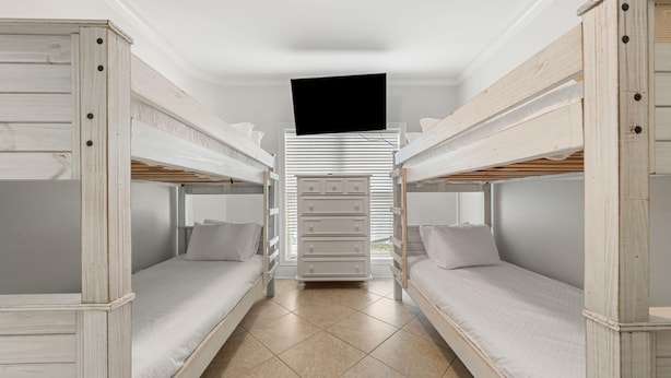 Ein Zimmer mit Etagenbetten, einem Schminktisch und einem Fernseher.