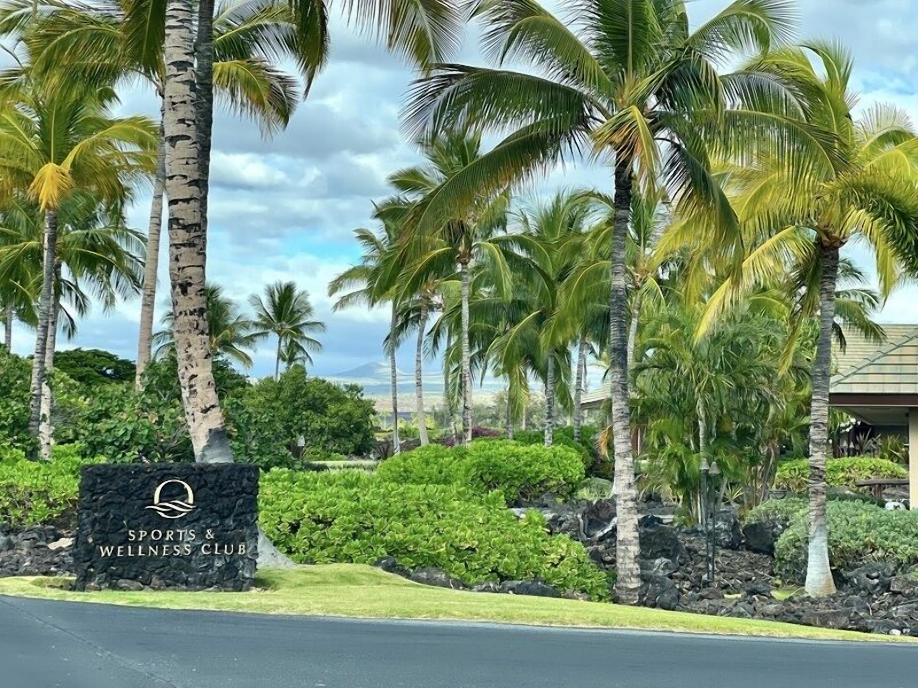Une enseigne pour un club de sport et de bien-être, avec un paysage tropical en arrière-plan.