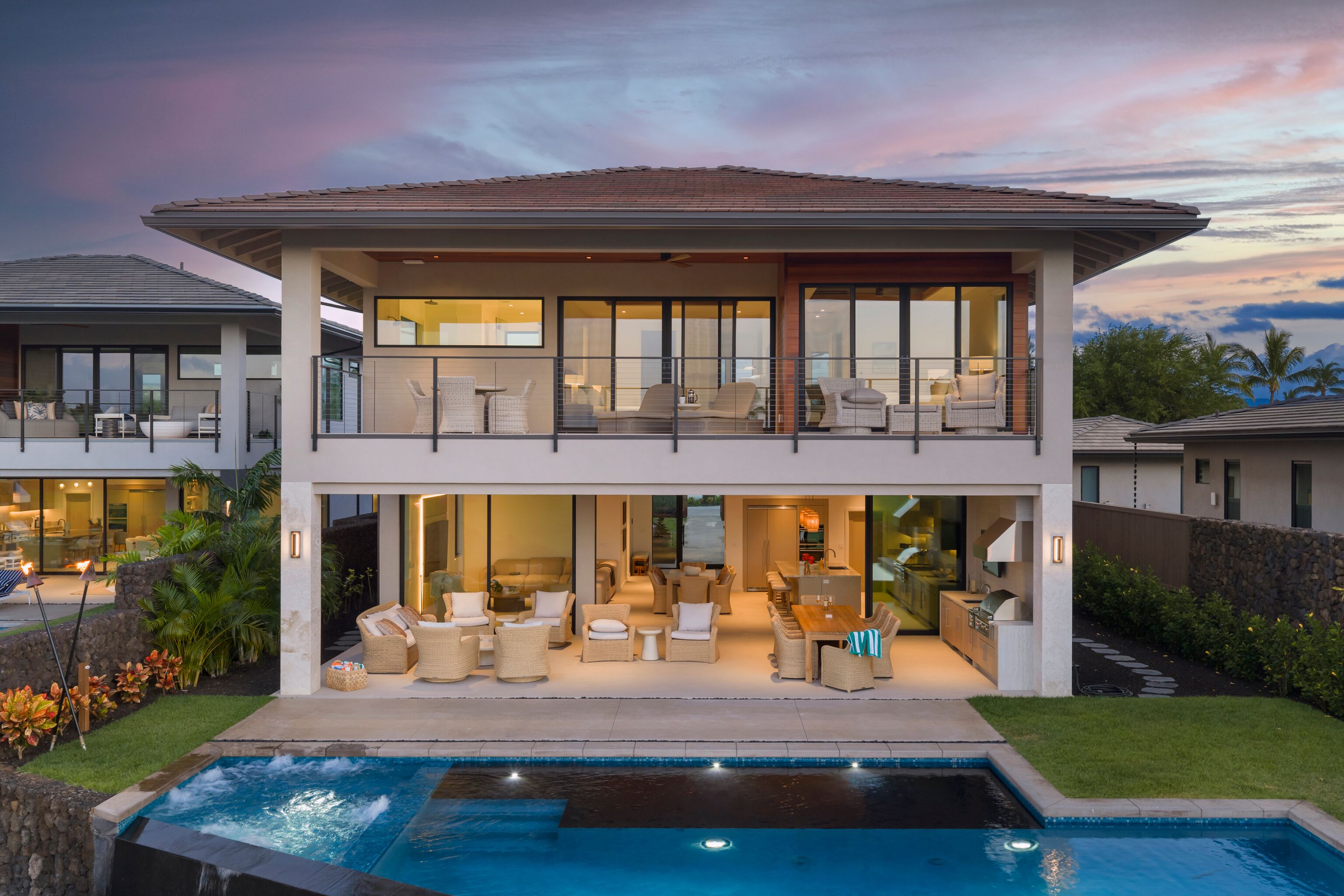 Uma casa de dois andares com varanda, piscina e interior bem iluminado.