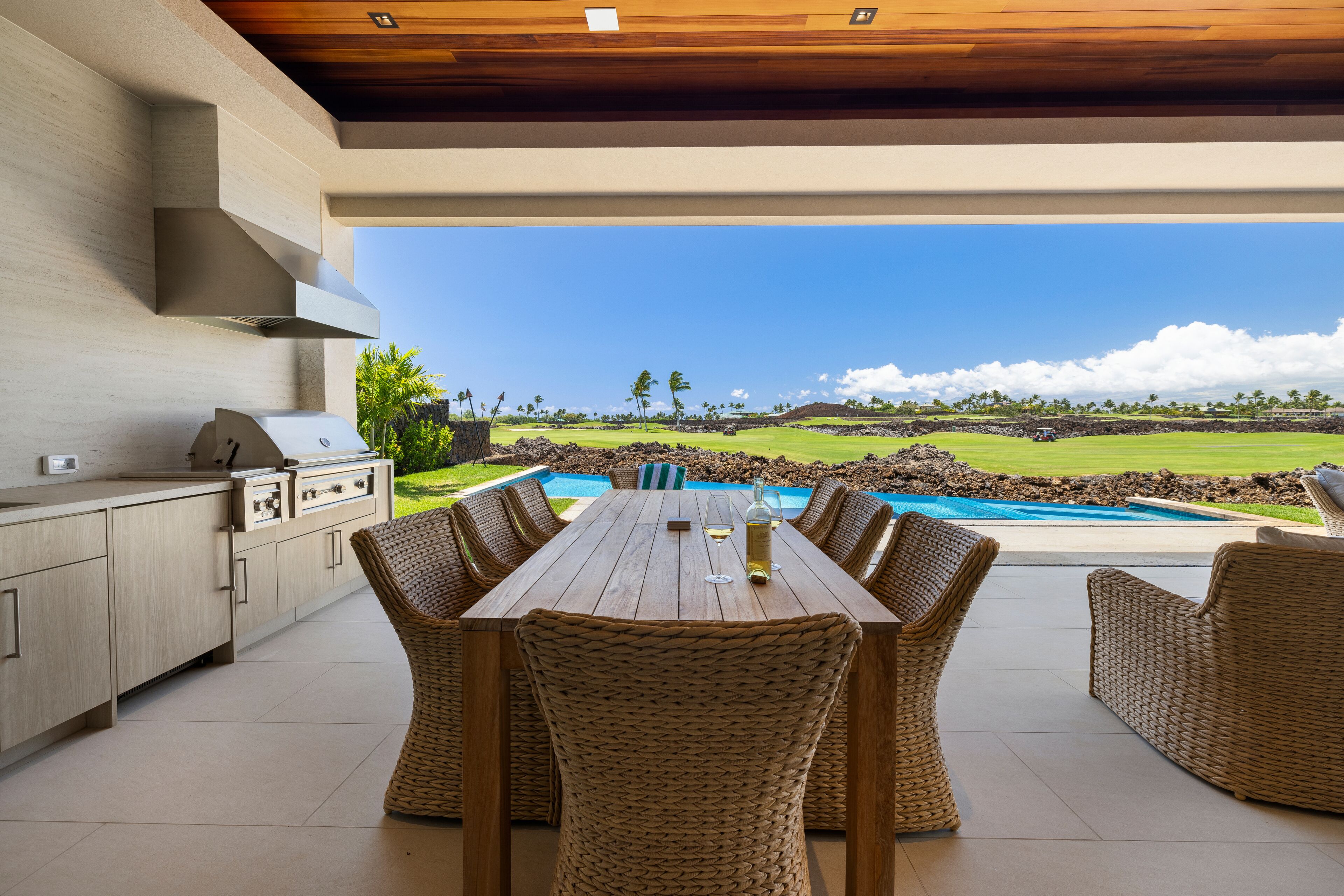 Un área de comedor al aire libre con vista a un campo de golf.
