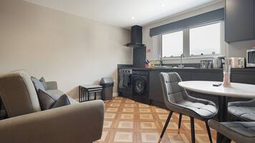A compact living space with a kitchenette, a dining area, and a sofa.