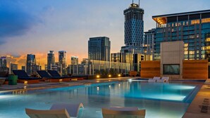 A rooftop pool with lounge chairs, a clear view of the city skyline, and modern buildings in the background. - 24th-floor 1BR Sleeps 4 | Rainey + Rooftop Pool (Austin)