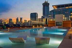A rooftop pool with lounge chairs, a clear view of the city skyline, and modern buildings in the background. - 24th-floor 1BR Sleeps 4 | Rainey + Rooftop Pool (Austin)