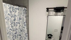 Une salle de bain équipée de toilettes, d’un lavabo et d’un rideau de douche.