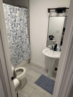 Ein Badezimmer mit Toilette, Waschbecken und Duschvorhang.