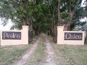 A pathway leading to a gated entrance with signs reading 'Pedro' and 'Chico'.