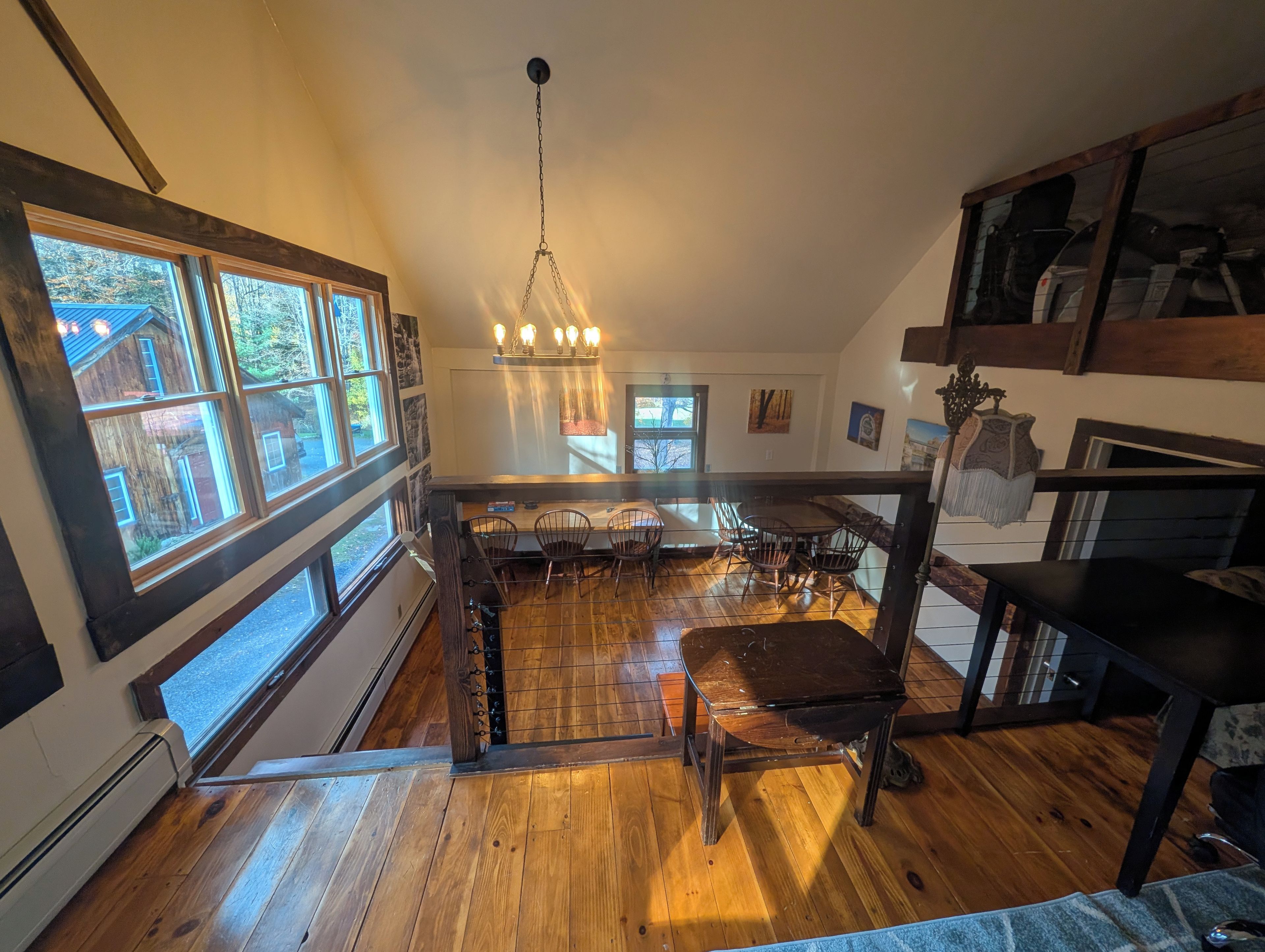 A spacious kitchen with a central island, large windows, and a hanging light fixture.