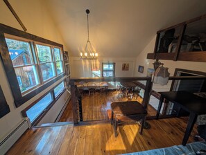 A spacious kitchen with a central island, large windows, and a hanging light fixture.