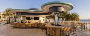 An outdoor bar area with seating and a view of the sea. - Two-Bedroom Condo on Daytona Beach (Daytona Beach)