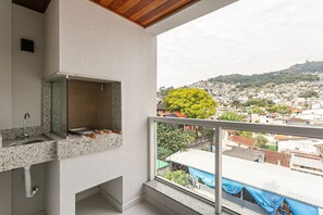 A balcony with a view of a hillside town. - Near Beira-Mar | Pool | Gym #CA106 (Florianópolis)