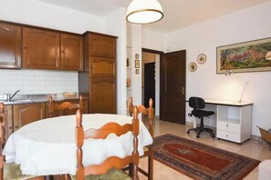 A room with a dining table, wooden cabinets, a desk, and a chair. - Casa Emy da Teresina – Relax in a Green Setting Just a Stone's Throw from Alba (Reala)