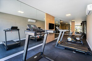 Een moderne sportschool met loopbanden, een elliptische trainer en een hometrainer.