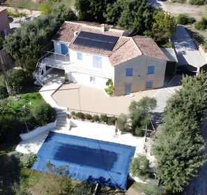 A house with a swimming pool, a covered outdoor area, and a garden.