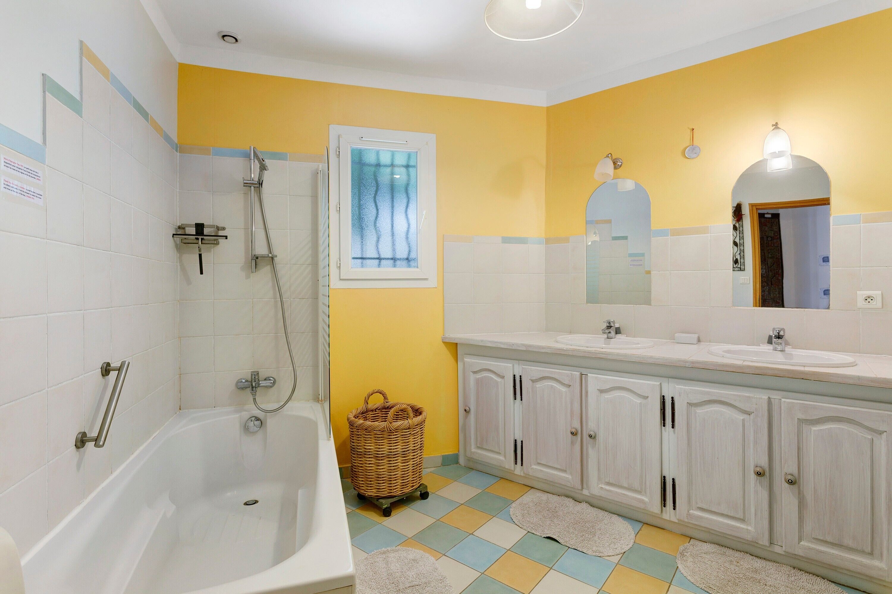 Une salle de bain avec une baignoire, une douche, un lavabo et un miroir.