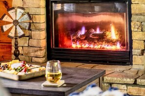 A fireplace with a stone wall and a wind chime. - Romantic - Firepit - Hot tub - Pet Friendly (Sevierville)