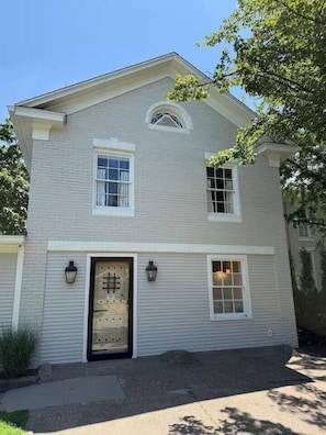 A two-story house with a symmetrical facade, a central entrance with a door, and two windows on the upper floor. - Full Carriage House + Hayloft (Fairfield)