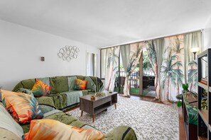 Ein Wohnzimmer mit einer Couch, einem Couchtisch und einem gemusterten Teppich.