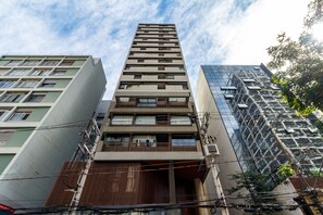 A modern high-rise building with multiple balconies and a reflective glass facade. - Studio Perto da Av Paulista e Masp Jardim Paulista (São Paulo)