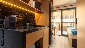 A compact kitchen with a modern design, a built-in microwave, and a coffee maker. - Studio Perto da Av Paulista e Masp Jardim Paulista (São Paulo)