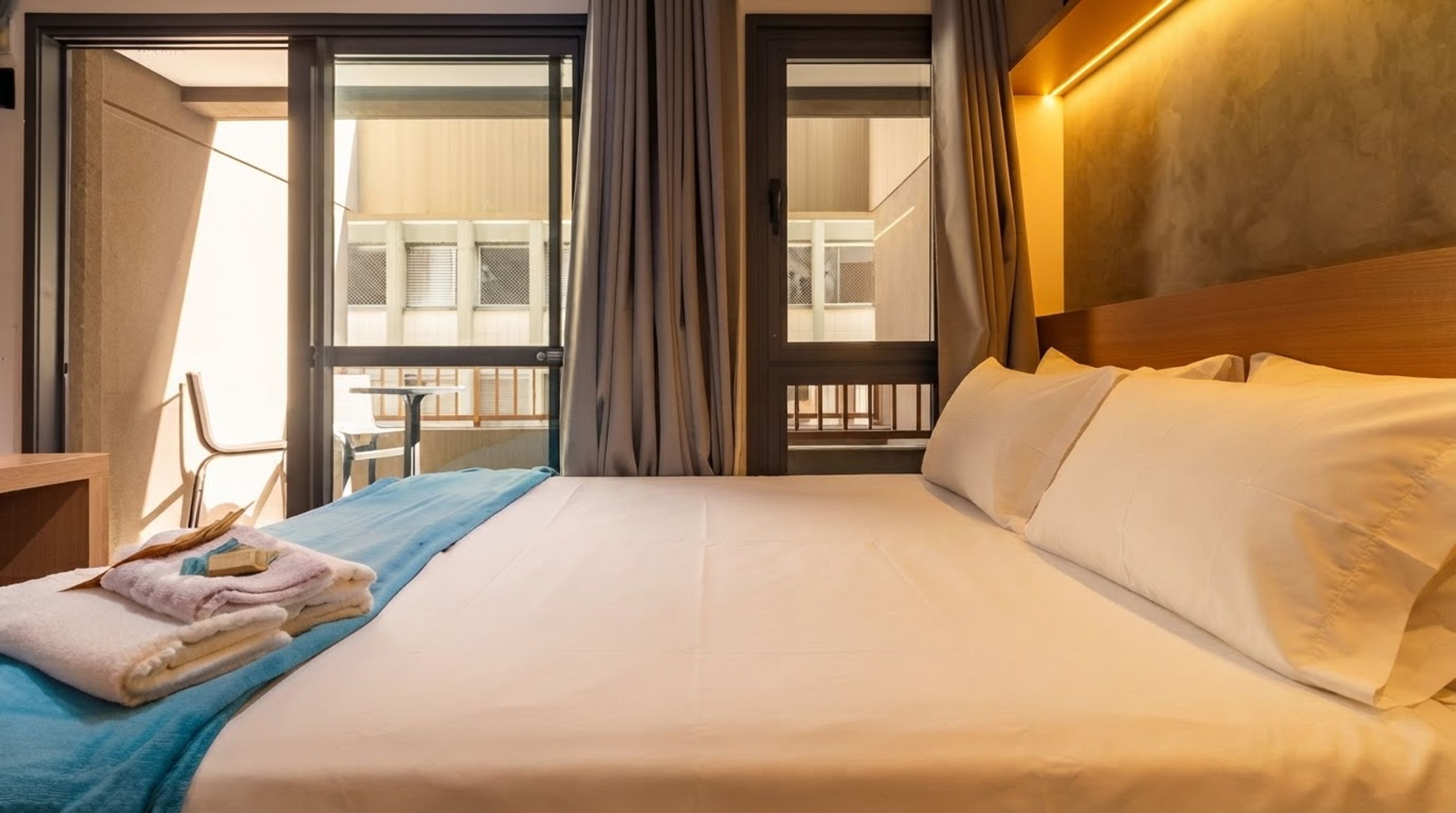 Ein Hotelzimmer mit Bett, Sessel und Blick ins Freie.