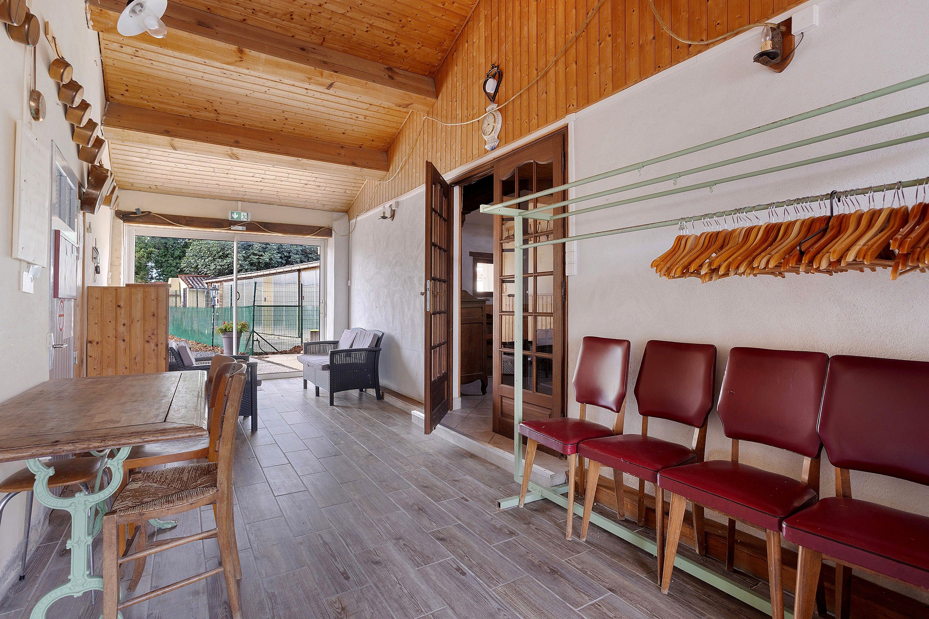 Un intérieur en bois comprenant une table à manger, des chaises et un espace avec un banc.