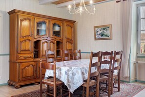 Comedor con un aparador de madera, una mesa con mantel y sillas.