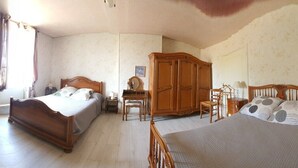 A bedroom with a bed, a wardrobe, a bedside table, and a chair.