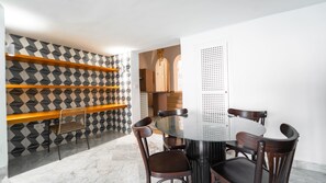 Un comedor con una mesa redonda, cuatro sillas y paredes con diseño geométrico.