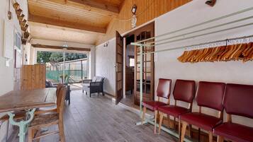 A wooden interior with a dining table, chairs, and a bench area.