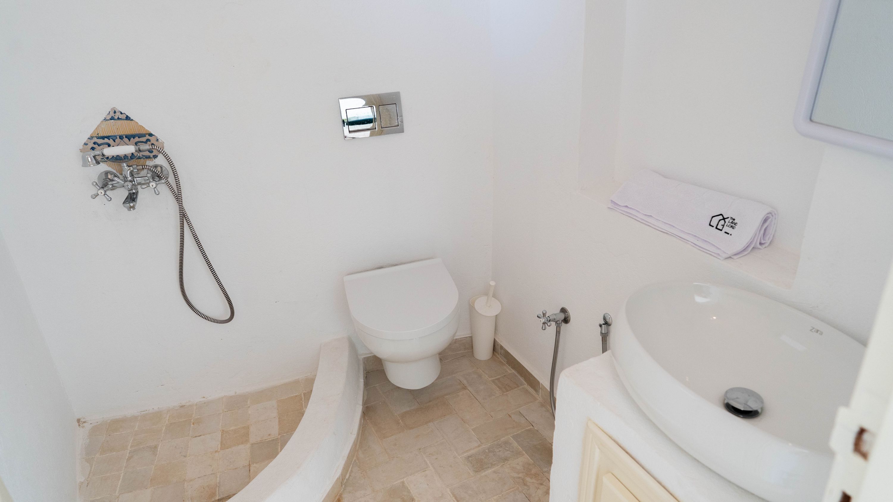 A bathroom with a toilet, bidet, and sink.