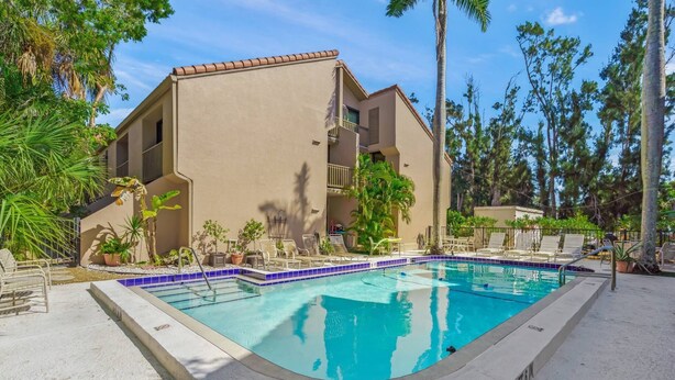 A swimming pool with lounge chairs and palm trees. - Sandy Cove Sanctuary | Renovated Ground-Floor Condo, Walk to Village, Private Beach & Fishing Pier (Siesta Key)