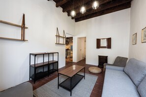 A living room with a sofa, a coffee table, and a bookshelf. - Ruote Nest by MMega (Firenze)