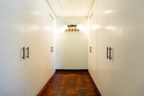 A hallway with wooden flooring and white walls, leading to a room with a wooden door and a light fixture above it. - Boutique Hotel-style Apartment in Cape Town City (Cape Town)