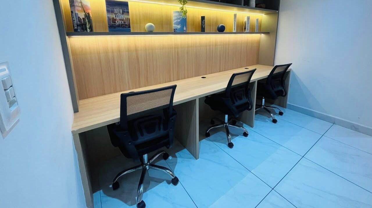 Una sala de conferencias con una larga mesa y cuatro sillas de oficina.